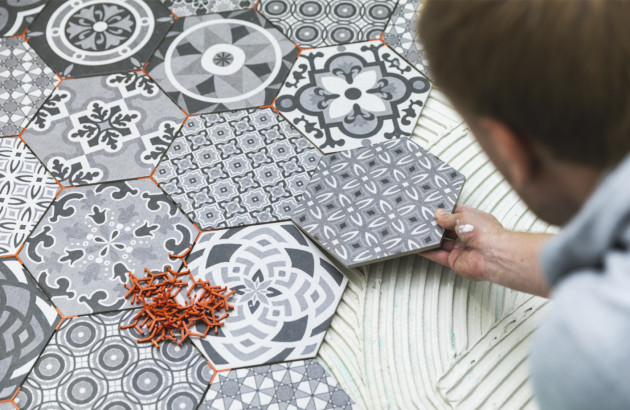 Homme qui pose des carreaux de ciment à motif hexagonaux sur le sol