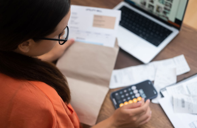 Femme qui fait des calculs sur son téléphone