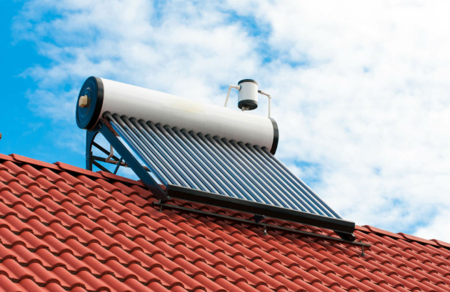 Panneau solaire sur un toit de maison relié à un chauffe-eau solaire