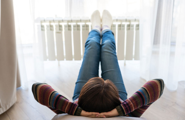 Femme qui se détend avec ses pieds sur le radiateur