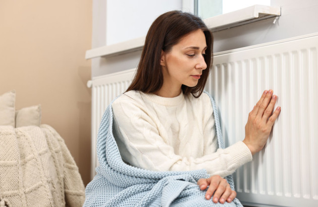 Femme qui touche son radiateur, elle a froid