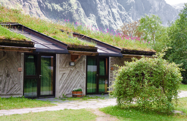 Maison avec de l'herbe et des panneaux solaires sur le toit