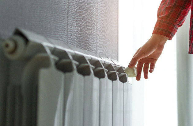 Main qui ajuste la température d'un radiateur