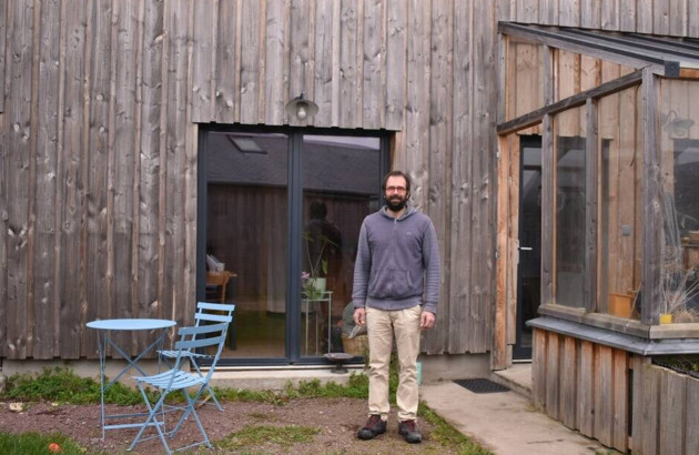 Homme très content d'avoir isolé sa maison en bois