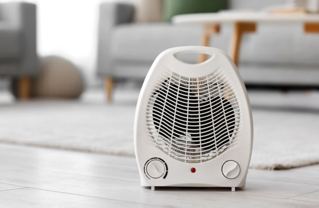 Radiateur soufflant blanc installé au sol dans un salon de maison