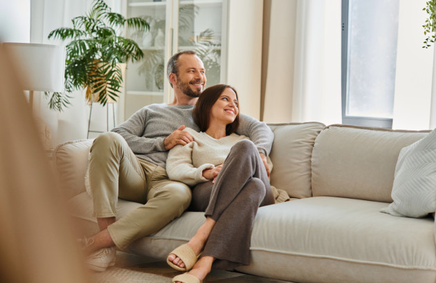 Couple heureux qui se prélasse sur un canapé