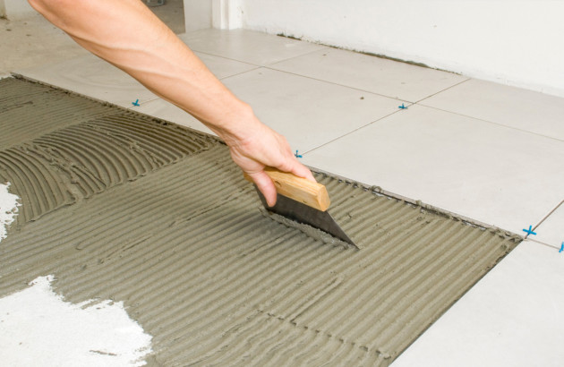 Homme qui prépare une surface à carreler