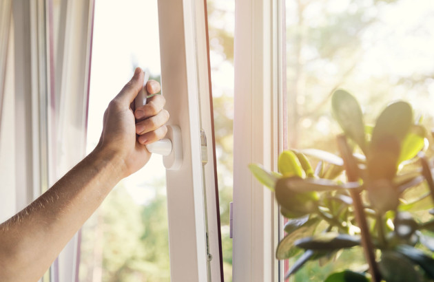 Personne qui ouvre sa fenêtre dans le but de ventiler son logement