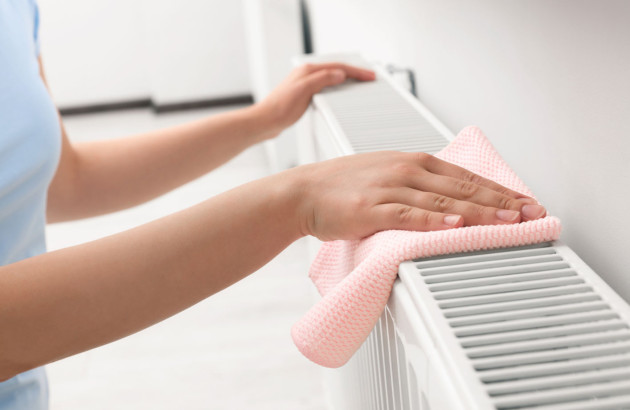 Femme qui passe le chiffon sur son radiateur