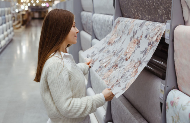 Femme en train de choisir du papier peint dans un showroom