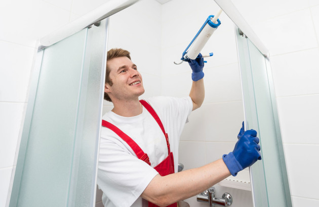 Homme posant du mastic d'étanchéité dans les joints