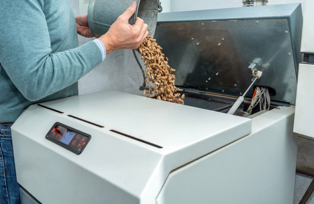 Personne alimentant une chaudière avec des pellets de bois