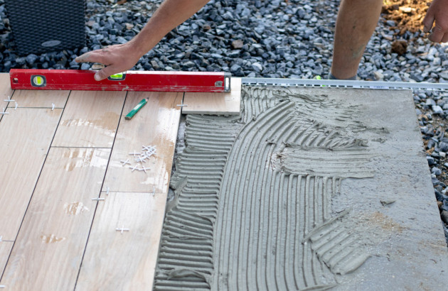 Professionnel en train de poser du carrelage sur le mortier