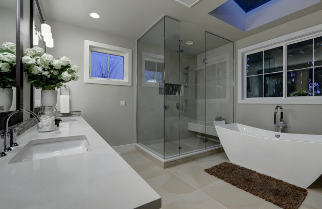 Salle de bains avec paroi de douche en verre et colonne douche à poser