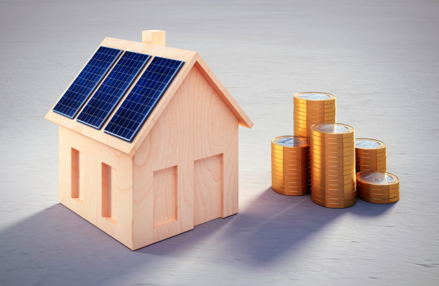 Maisonnette en bois avec des panneaux solaires et des pièces de 1 euro empilées à droite