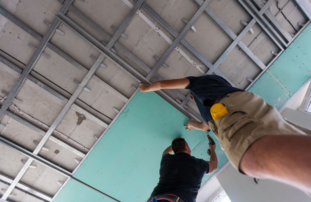 Artisans qui installent un système de chauffage par le plafond