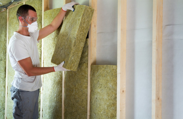 Homme qui pose des blocs d'isolant