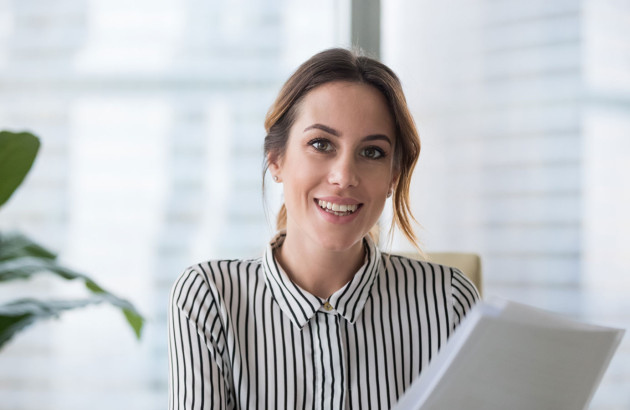 Femme conseillère dans un bureau qui tient une feuille de papier