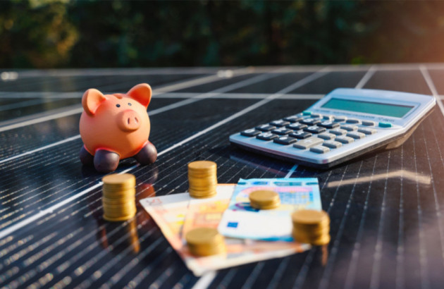 argent, calculatrice et cochon tirelire sur des panneaux solaires