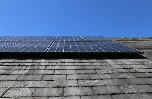 Vue de près de panneaux solaires installés sur un toit en tuiles en ardoise