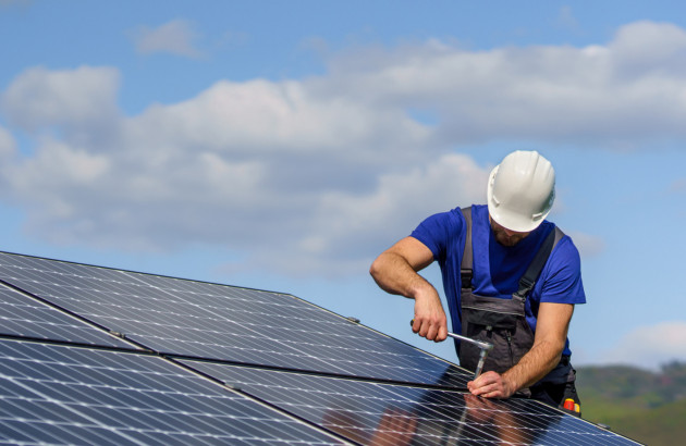 Homme qui travaille sur un panneau solaire