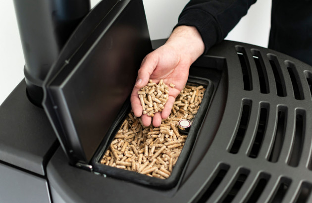 Homme qui met des pellets dans son poêle à pellets