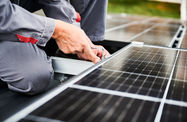 Homme qui installe un support de panneau solaire