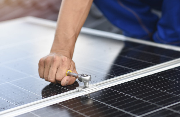 Personne en train de visser un panneau solaire