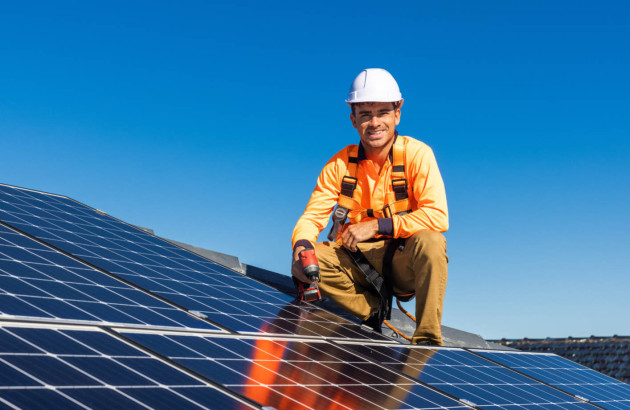 Ouvrier souriant sur un panneau photovoltaïque