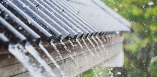 eau de pluie qui ruisselle sur un toit de maison