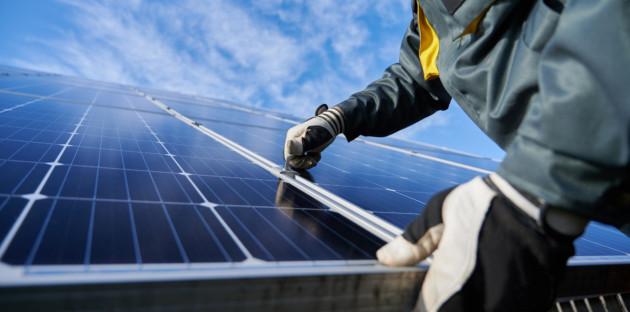 Homme qui installe un bac à lester pour panneau solaire